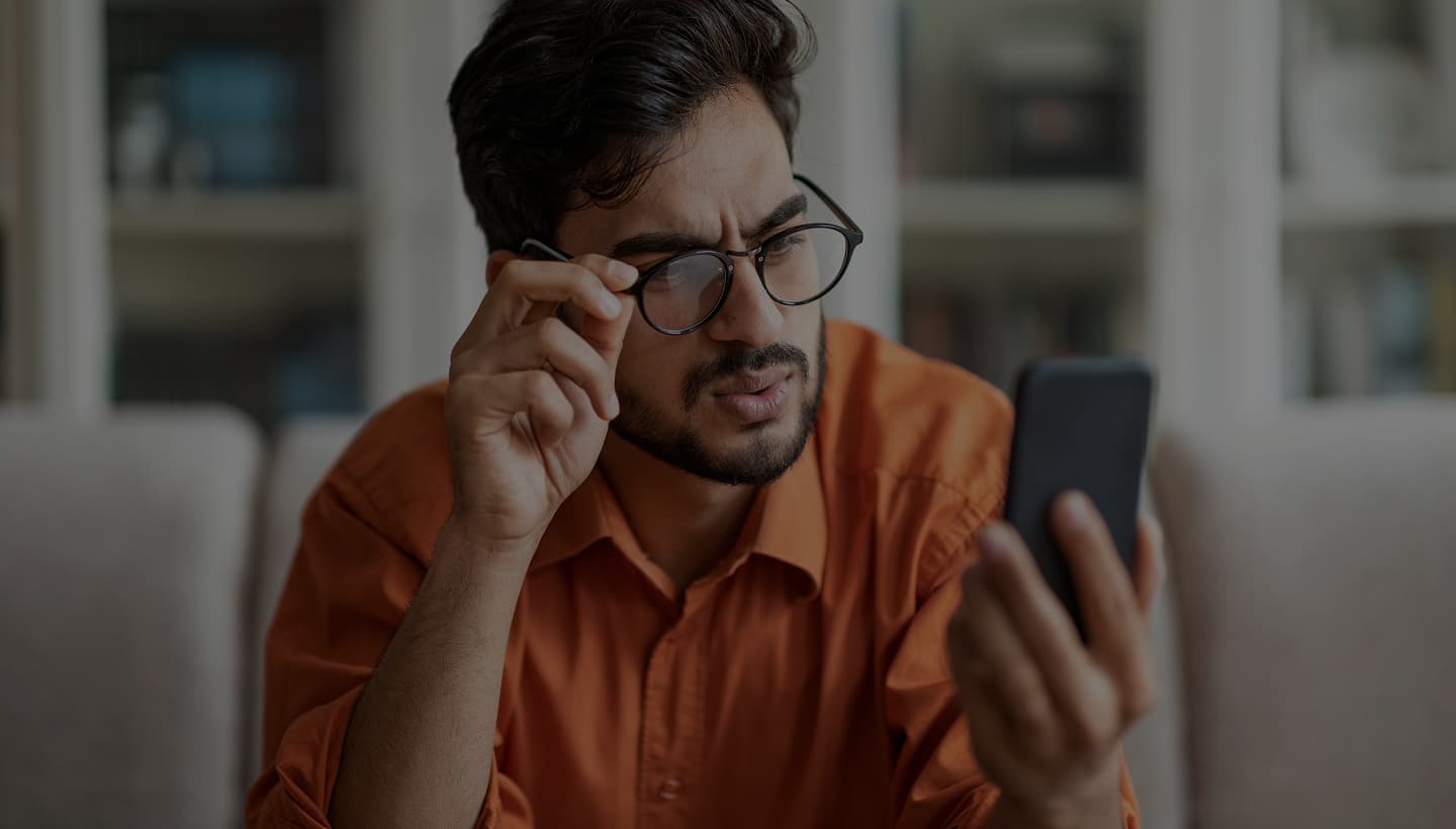 Frustrated man squinting at a healthcare website on his phone